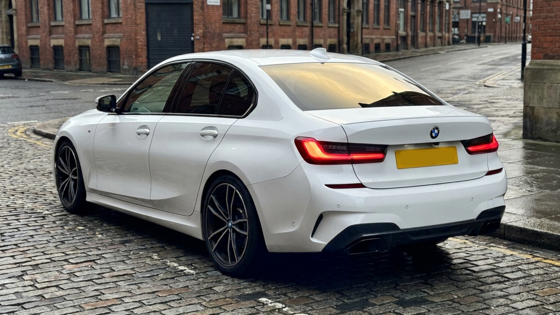 BMW 3-Series G20 M Sport, вид сзади 3/4 в подземном паркинге, низкая посадка