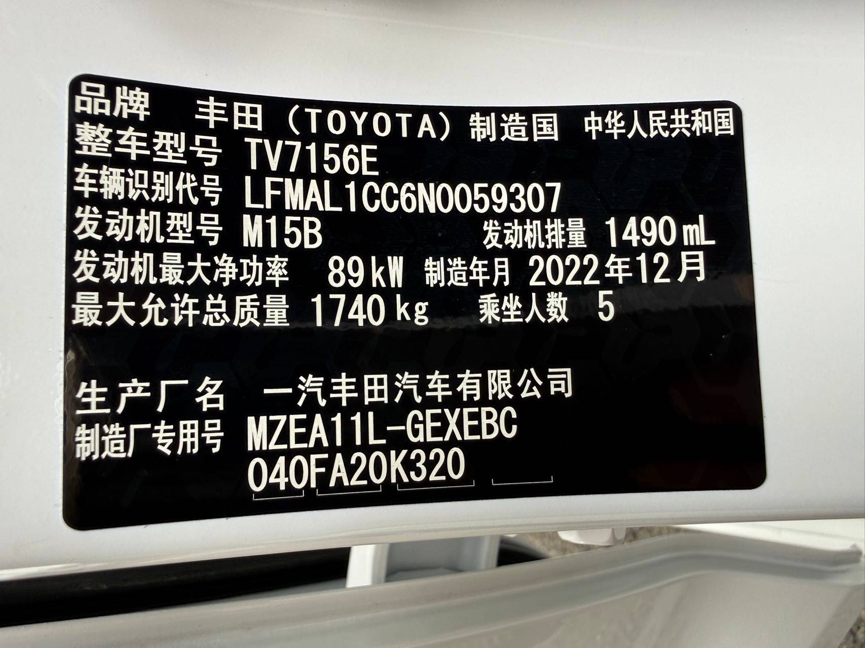 Заводская бирка Toyota Corolla в дверном проёме: FAW Toyota, мотор M15B, 89 кВт, декабрь 2022