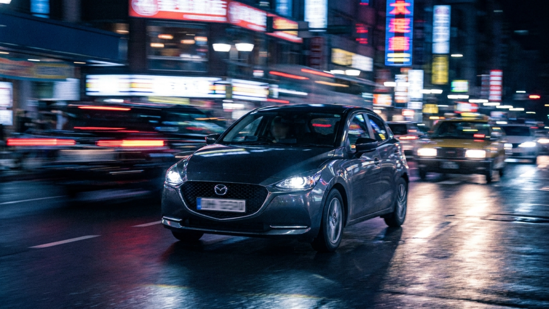 Mazda Demio DJ в вечернем городском потоке, ночные огни, лёгкая проводка