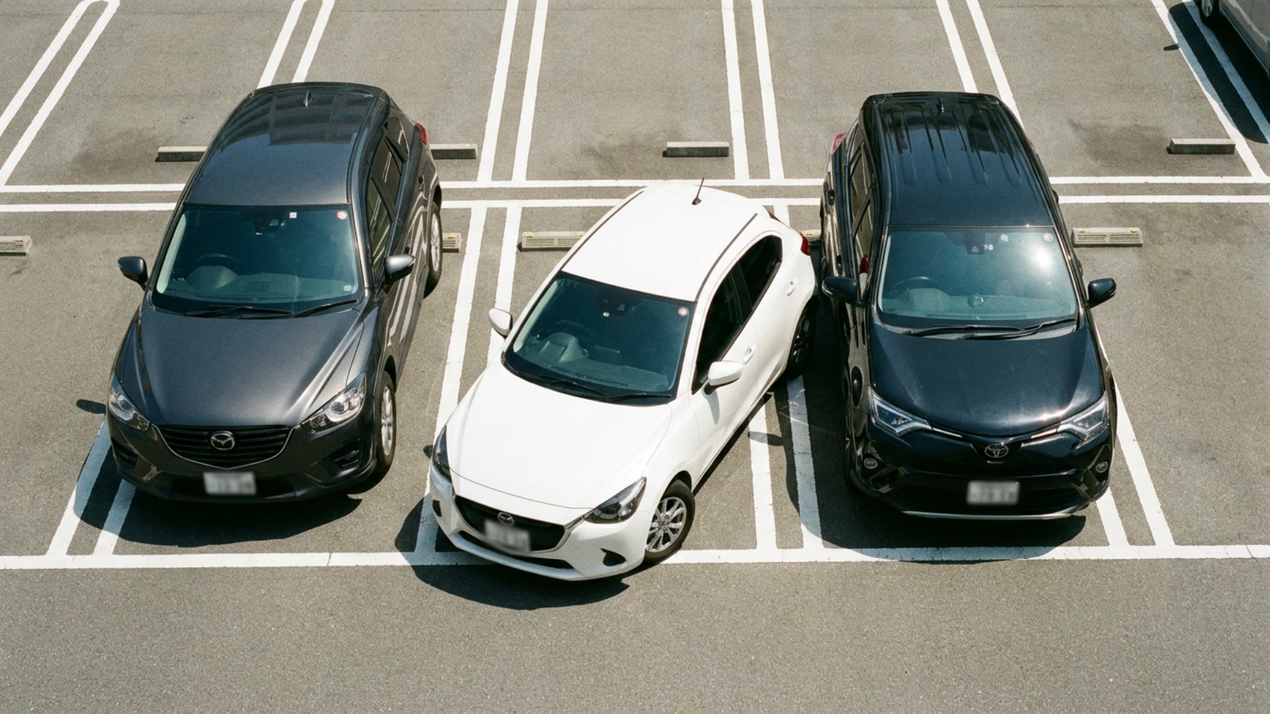 Mazda Demio DJ паркуется в тесном дворе, яркий полдень