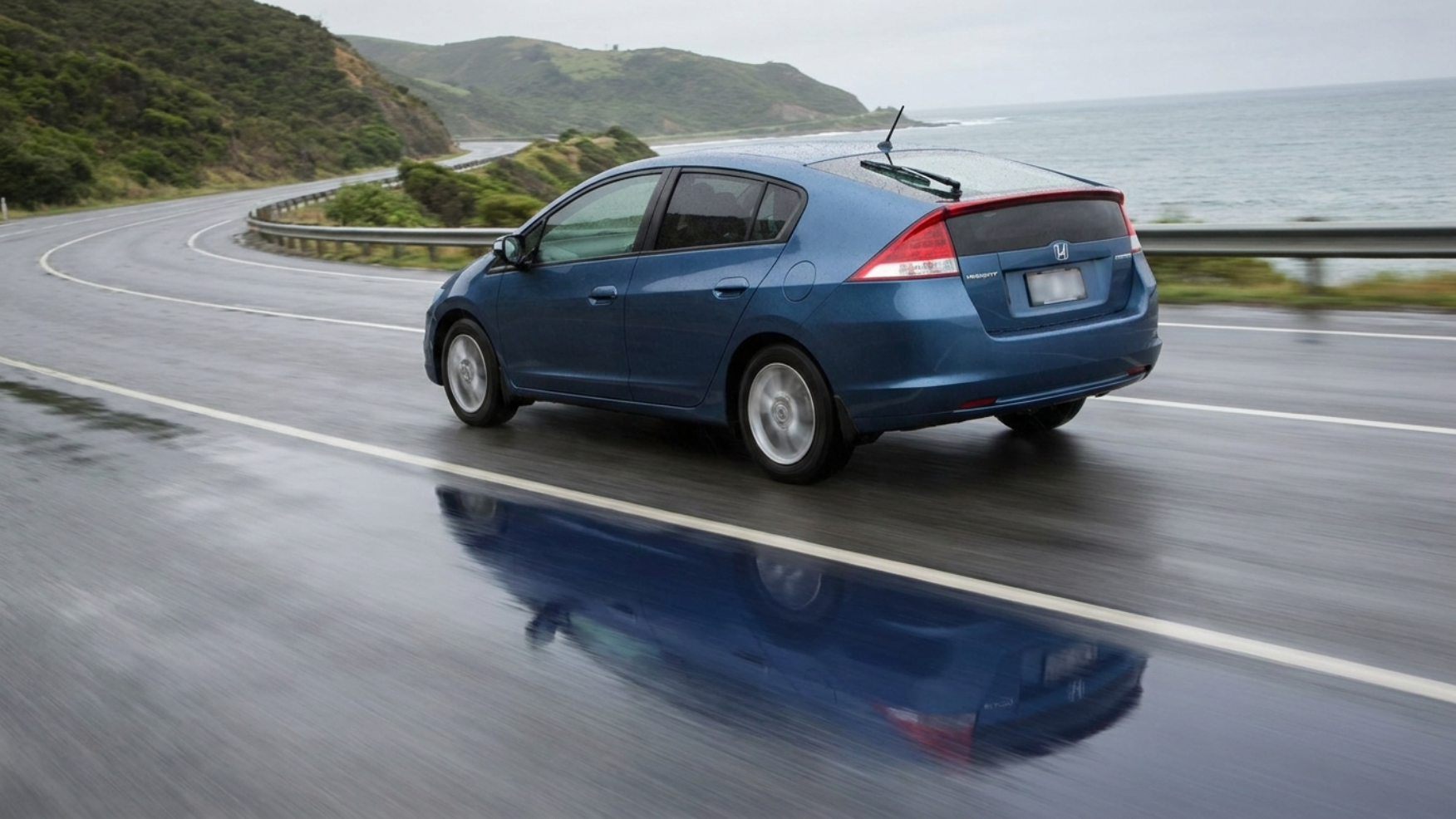 Honda Insight на приморской трассе в пасмурную погоду, мокрый асфальт