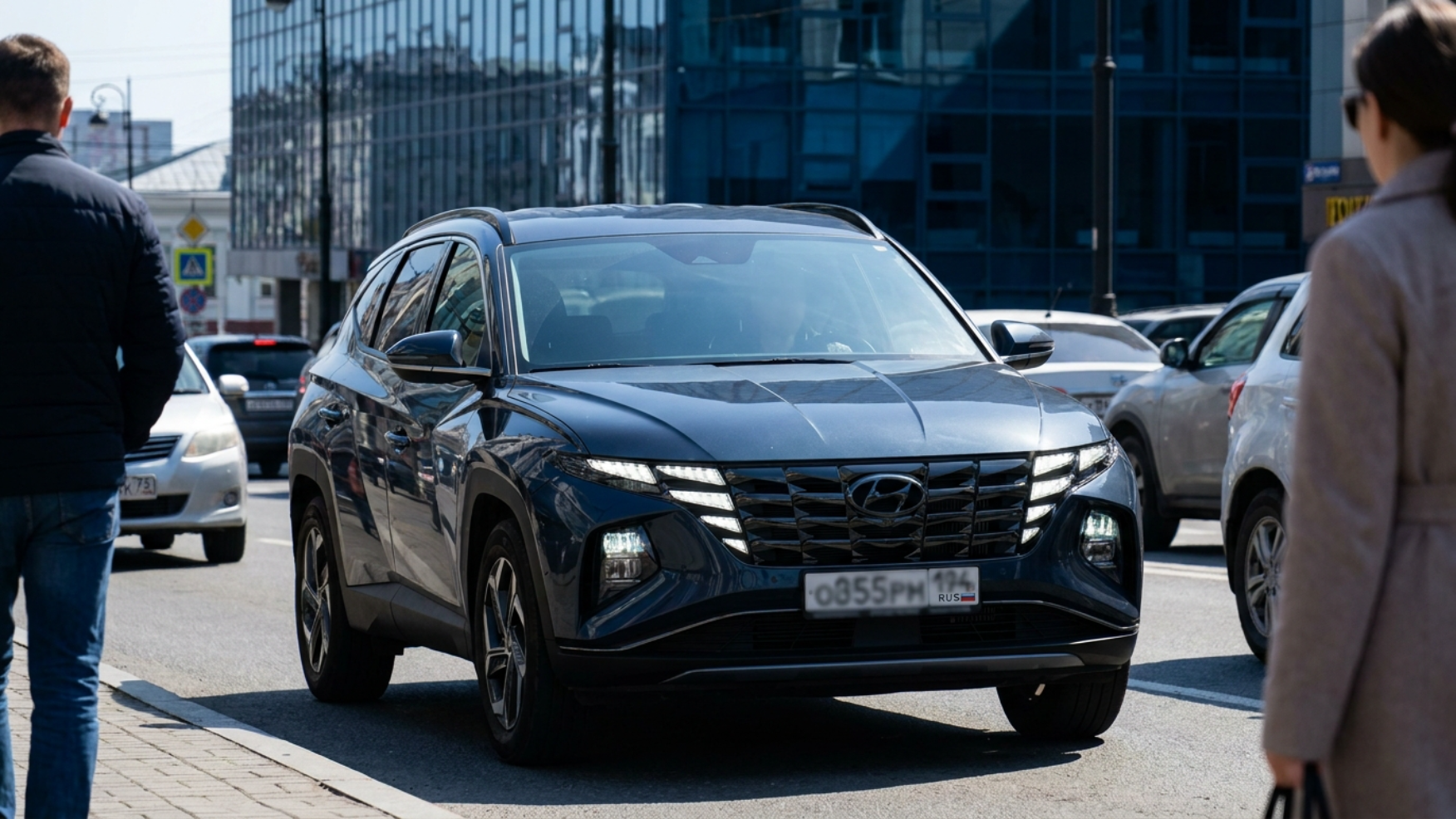 Hyundai Tucson с агрессивной решёткой в городском потоке днём — на машину оборачиваются