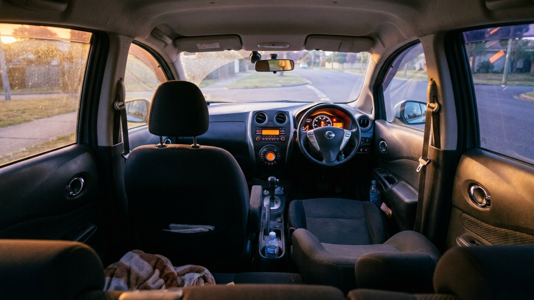 Салон Nissan Note E12 общим планом, приборная панель и передний ряд, вечерний свет