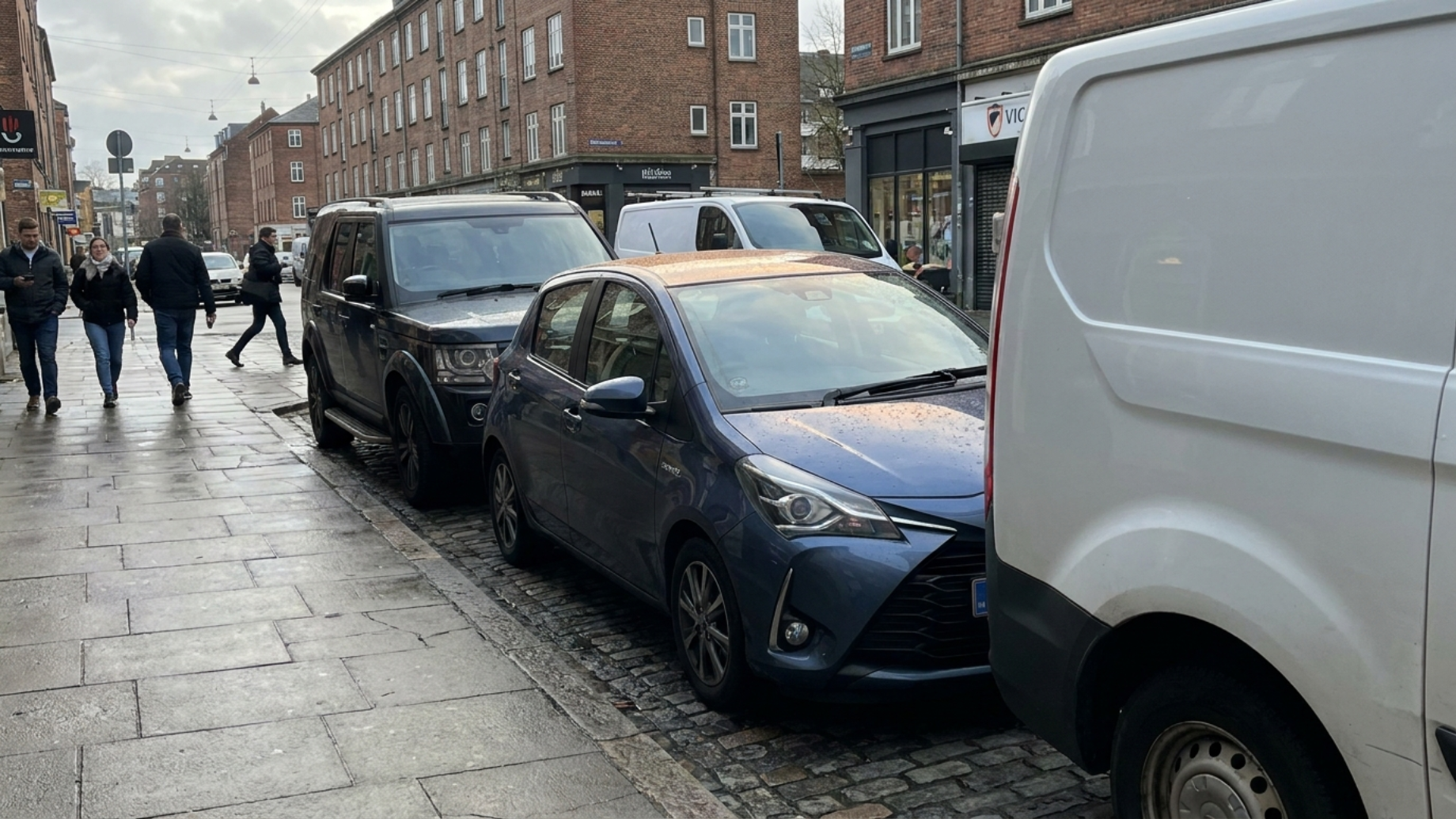 Toyota Yaris четвёртого поколения на тесной городской парковке, компактный размер