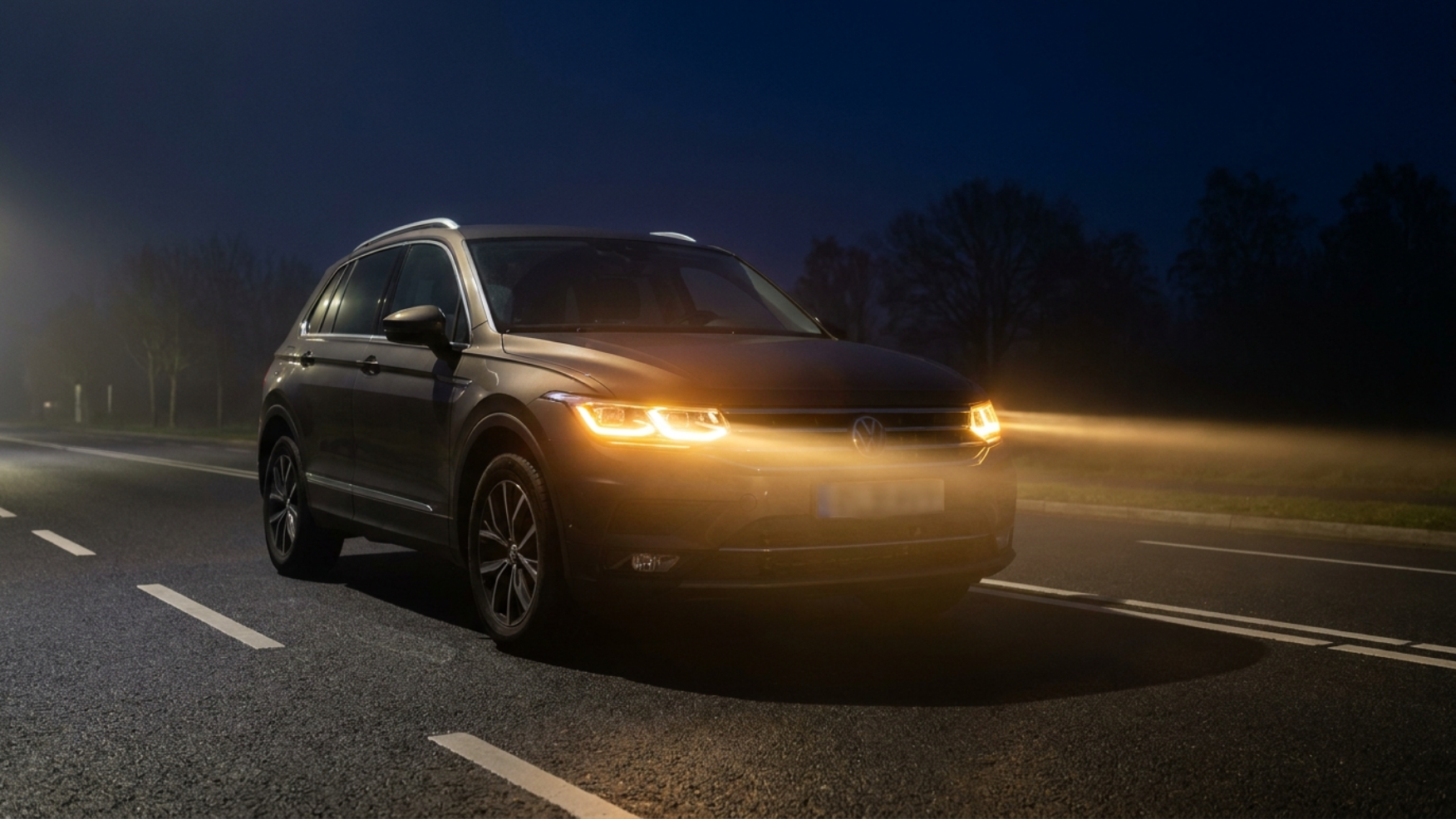 Volkswagen Tiguan ночью со включённой адаптивной оптикой iQ.Light освещает пустую улицу