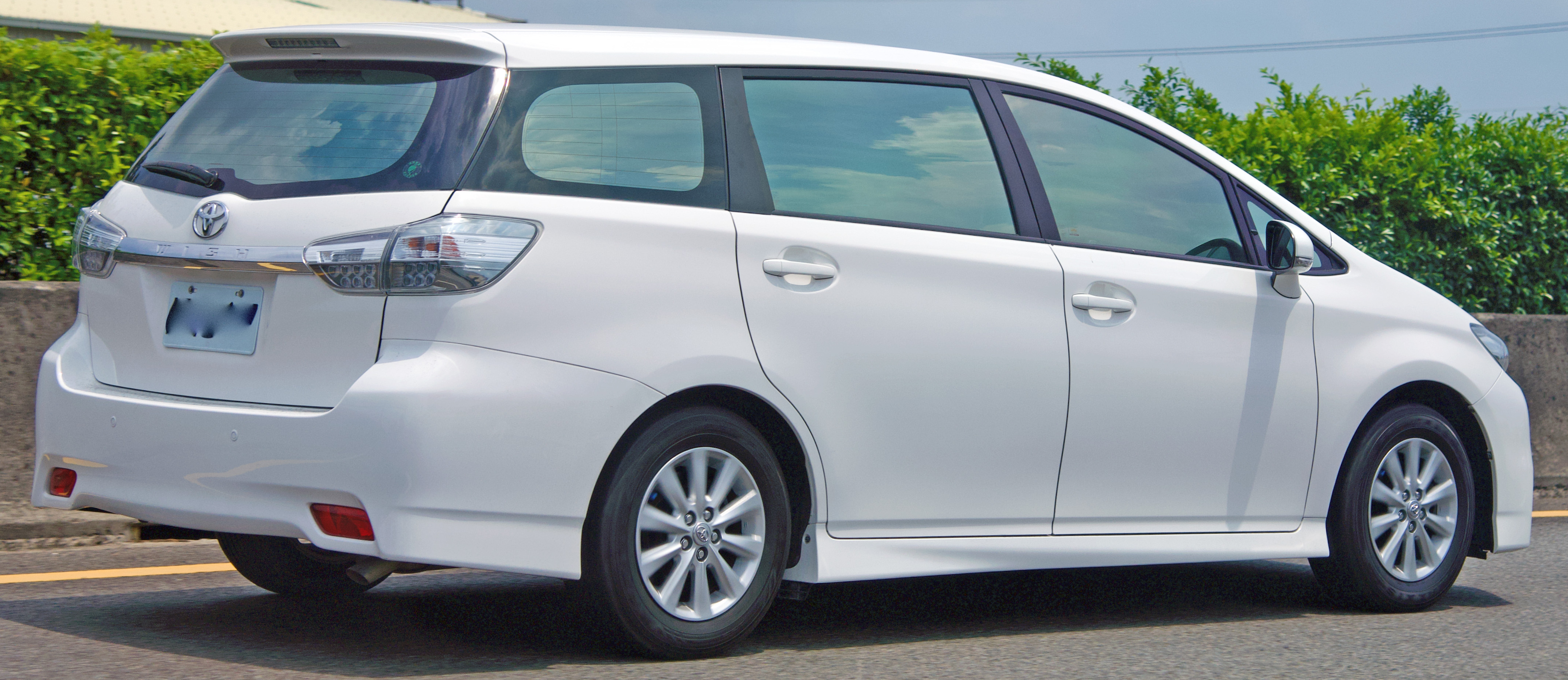 Белый Toyota Wish рестайлинга в движении, реальное фото, профиль «раздутого универсала»